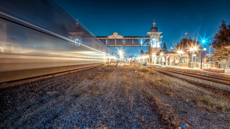 train_passing_a_station_at_night_in_long_exposure_hdr.jpg