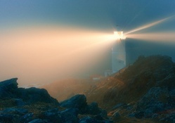glowing lighthouse in the fog