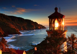 glowing lighthouse on a red oregon sea coast