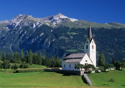 wonderful church in a meadow below mountains