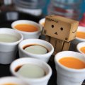 Danbo standing next to cups