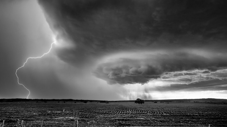 lightning storm over fields in grayscale