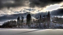 castle on a hill above a frozen lake in winter hdr
