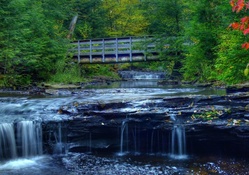 wooden bridge over rocky forest stream