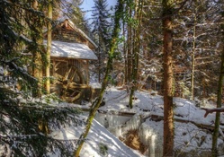 mill in the forest by a frozen waterfall