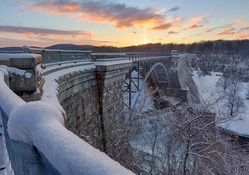 tall steel bridge over waterfall in winter