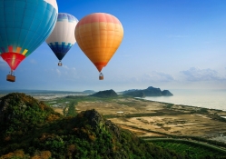 hot air balloons flying over seacoast