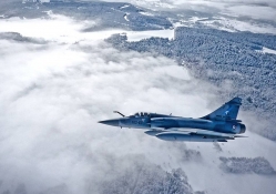 french mirage fighter plane over forest in winter