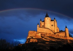rainbow over castle on a cliff