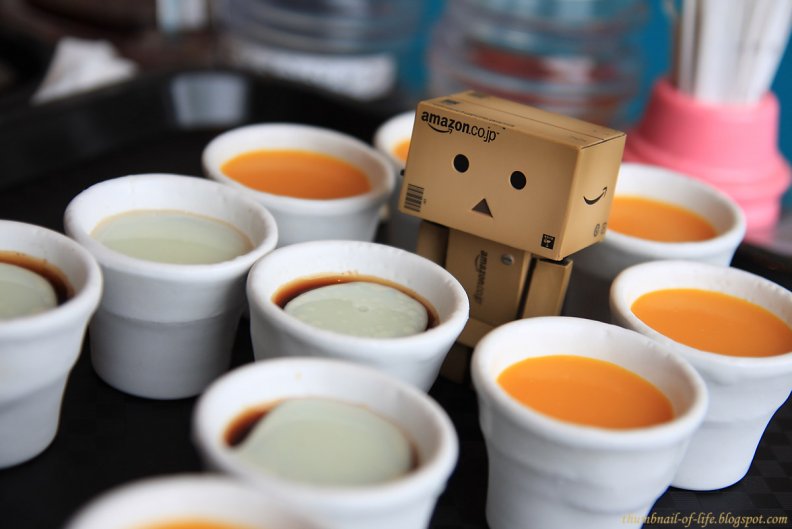 Danbo standing next to cups